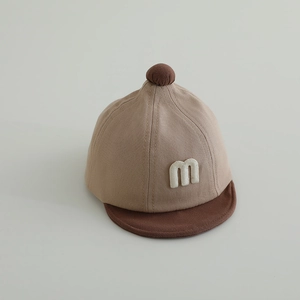 Detail einer weichen Baby-Kappe mit besticktem M und kontrastierendem Schirm