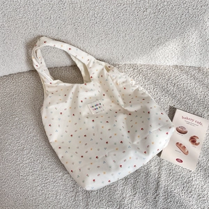 Detail of floral tote bag showing fine fabric texture and woven brand label
