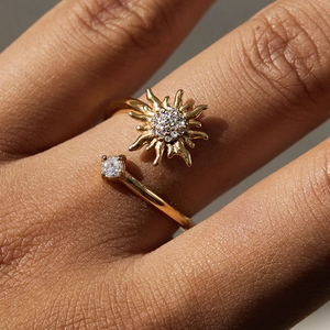 Detailed view of sunburst gold ring with zircon on model hand showing adjustable band