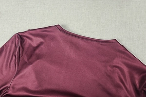 Close-up of wine red satin dress showing fine double-needle stitching on the V-neckline
