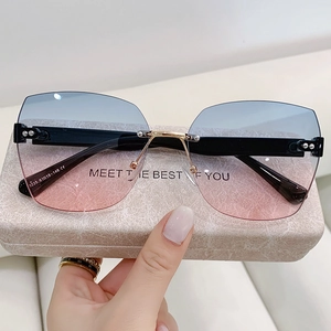 Detail view of rimless sunglasses featuring blue-pink gradient lenses and golden metal hinges