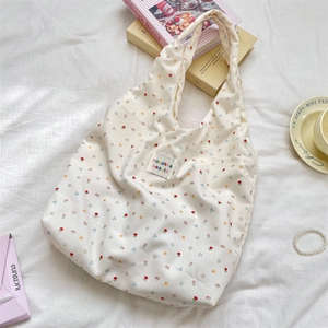 Macro view of floral pattern on cream tote bag with stylish fabric brand label
