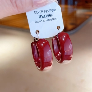 Close-up of vintage dark red enamel S925 silver hoop earrings on a display card
