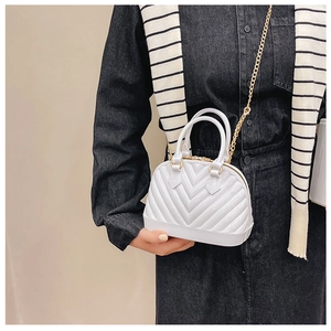 Close-up of a white mini jelly shell bag with V-quilted texture and gold chain strap