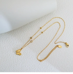 Detailed close-up of 18K gold butterfly necklace with laser patterns and small crystals