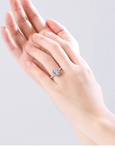 Close-up of a 2-carat floral moissanite ring in silver finish worn by a model