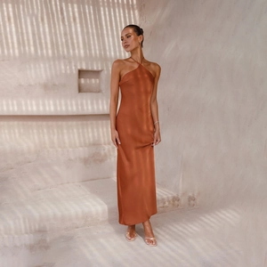Detail view of the sleek burnt orange satin halter neck dress with elegant open back design