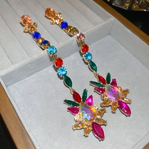 Macro shot of colorful teardrop drop earrings with rhinestones on a gray jewelry tray