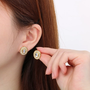 Gros plan de boucles d'oreilles vintage en acier inoxydable doré 18K avec strass ovales