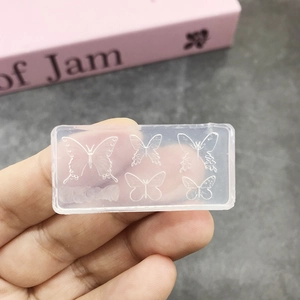 Close-up of clear silicone nail art mold with five unique butterfly patterns for DIY craft