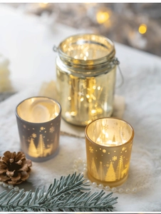 Close-up of Christmas glass candle holders with reindeer patterns on white faux fur