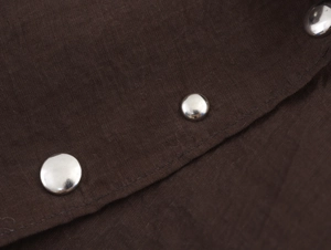 Détail du tissu texturé marron foncé avec des accents de clous métalliques argentés