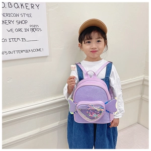 Close-up of girls purple glitter backpack with heart sequins and butterfly wings