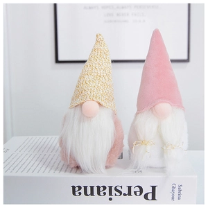Close-up of Nordic plush gnomes with knitted gold and pink velvet hats and white beards