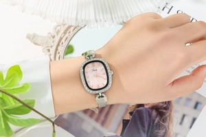 Detail view of fashion women's oval quartz watch with silver mesh band on wrist