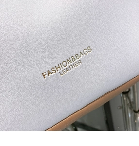 Macro shot of lychee grain leather tote bag with gold logo and fine stitching details