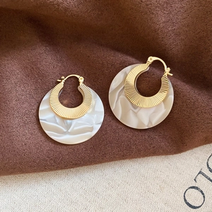 Detail showing marble resin texture and gold pleated metal finish on round earrings