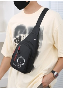 Close-up of black crossbody chest bag with luminous music graphic and red zipper trim
