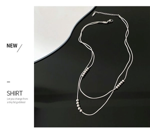Detail of silver double-layered snake chain necklace with beads and lobster clasp