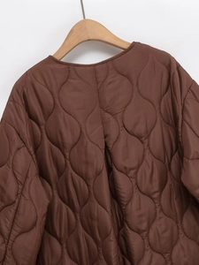 Detailed view of dark brown diamond quilted jacket collar and wood hanger display