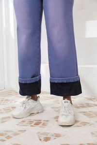 Dettaglio dei pantaloni a vita alta con fodera in pile nero caldo e bordo ripiegato