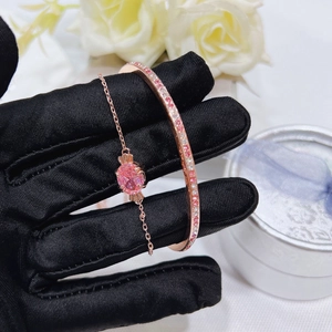 Close-up of rose gold bracelet and bangle set featuring pink crystals and pavé zircon stones