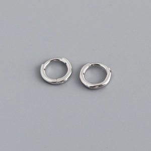 Detail view of silver S925 sterling silver huggie hoop earrings with a polished finish