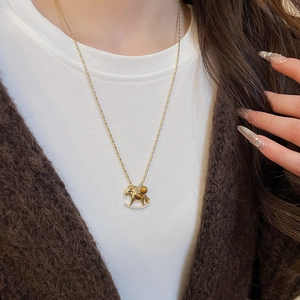 Detail of a golden pony necklace with tiger eye stone and zircon on a model
