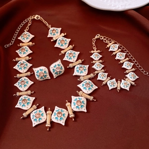 Detail of vintage jewelry set with white enamel and amber crystals on dark fabric