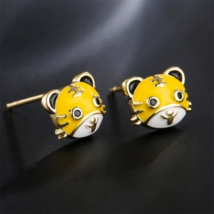 Minimalist 18K gold-plated tiger stud earrings with enamel details on a dark background