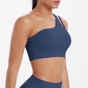 Detail of navy blue one-shoulder sports bra with asymmetrical straps and matte texture
