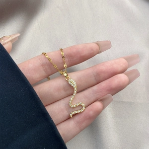 Close-up of snake pendant necklace with shimmering crystals on an 18K gold-plated chain