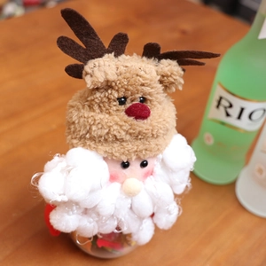 Christmas Santa doll candy jar with brown plush reindeer hat on wooden desk