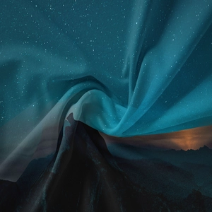 Detail of galaxy tapestry fabric showing surreal mountain landscape and starry nebula