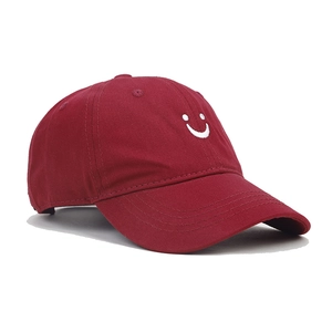 Detail view of burgundy cotton baseball cap featuring high-quality smiley face embroidery