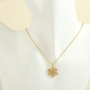 Close-up of golden snowflake pendant necklace with green gemstone on a display stand