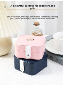 Detail of pink and navy leather jewelry boxes with golden crown and button closure
