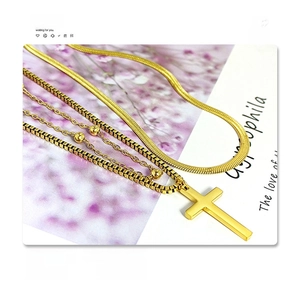 Detail of multi-layered 18k gold plated titanium steel necklace with cross pendant