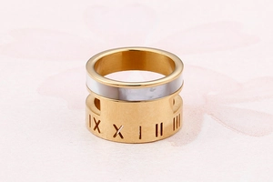Macro detail of gold wide ring with white shell inlay and Roman numeral engravings