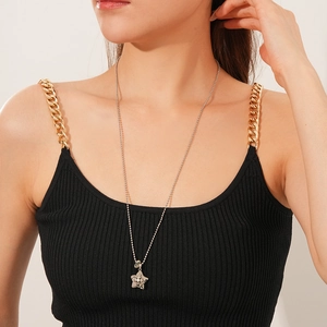 Close-up of star shaped pendant with cross detail on a silver bead chain necklace