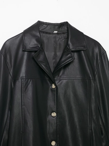 Detailed close-up of a black faux leather jacket with grey buttons and lapel collar