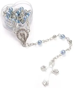 Détail de chapelet en perles bleu clair avec croix argentée dans une boîte coeur