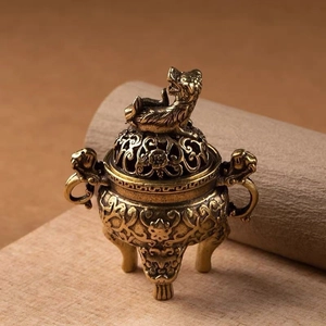 Detailed view of an antique brass incense burner featuring hollowed lid and beast handle
