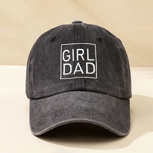 Close-up of white GIRL DAD embroidery on washed dark grey denim cotton baseball cap