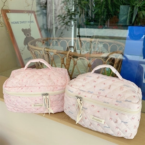 Detail of pink quilted bear makeup bags with floral patterns and branded zipper pullers