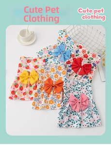 Flat lay of five floral pet summer dresses with large bows and light cotton fabric