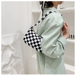 Side view of checkered shoulder bag with black and white patterns and a zipper closure