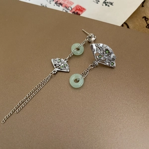 Detail von silbernen Bambusohrringen mit grünen Jade-Ringen und Metallquasten