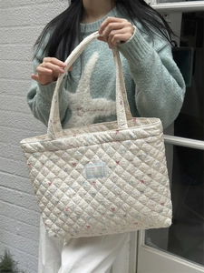 Close-up of quilted floral tote bag with Bearkka Studio label and diamond stitching