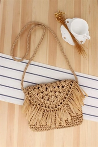 Detailed view of the woven shoulder bag with tassel flap, perfect for seaside and daily style.